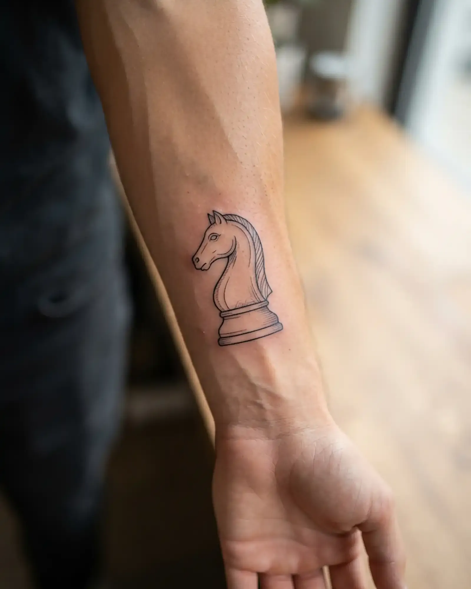Fine-Line Schach-Springer-Tattoo am Unterarm, fotorealistische Nahaufnahme