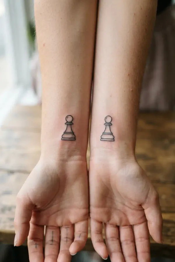 Zwei Handgelenke mit passenden Schach-Tattoos