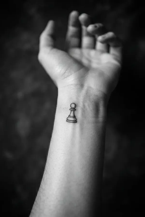 Schwarz-Weiß-Editorial-Aufnahme eines Handgelenk-Tattoos