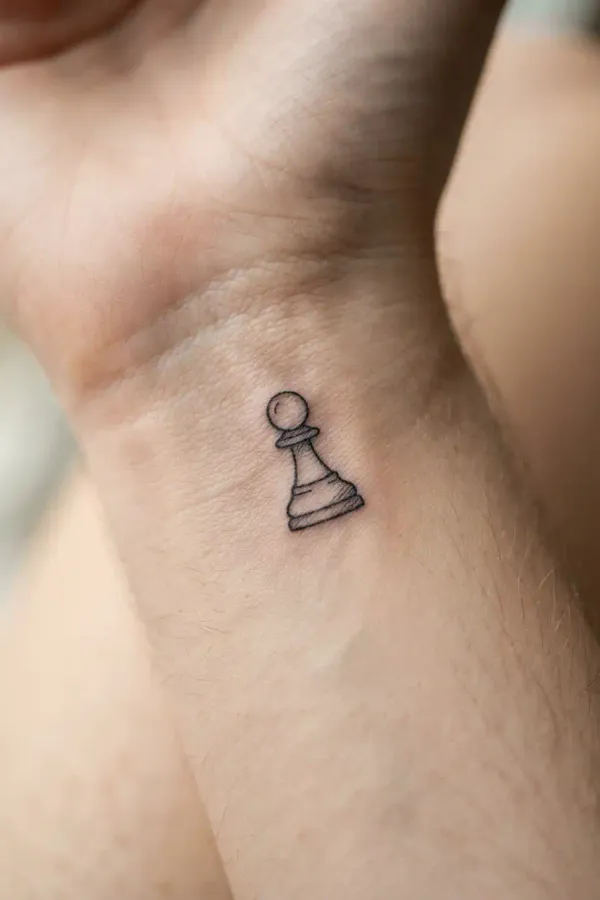 Makroaufnahme eines winzigen Schach-Tattoos am Handgelenk
